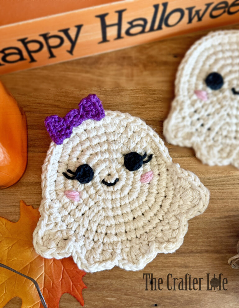 A Crochet Ghost Coaster called the Ghoster. White Halloween coaster laying on a wood table.
